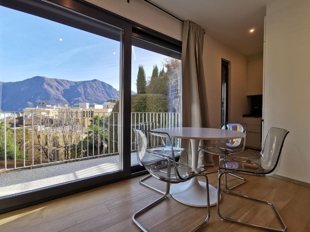um quarto com uma mesa e cadeiras e uma grande janela em LOFT 18! Cozy loft downtown near the lake with FREE PARKING em Lugano