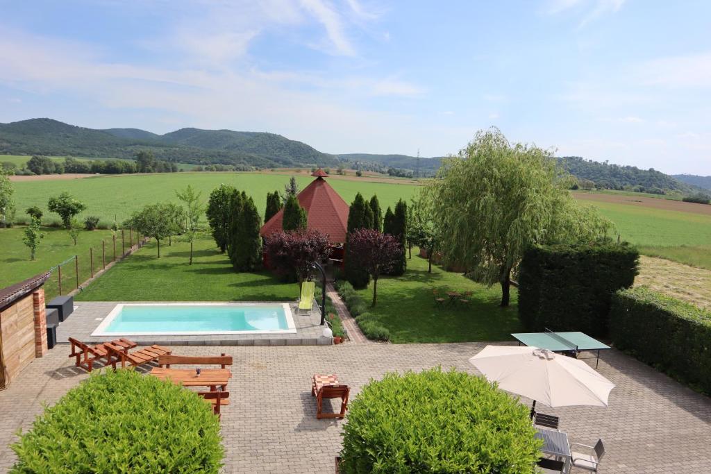 a swimming pool in a garden with a view of a field at Memory Vendégház in Várvölgy