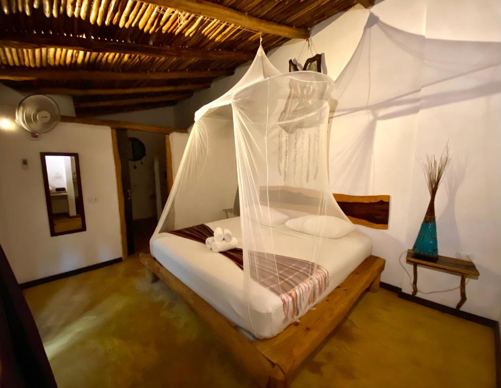 een slaapkamer met een bed met een klamboe bij Pacha Tulum in Tulum