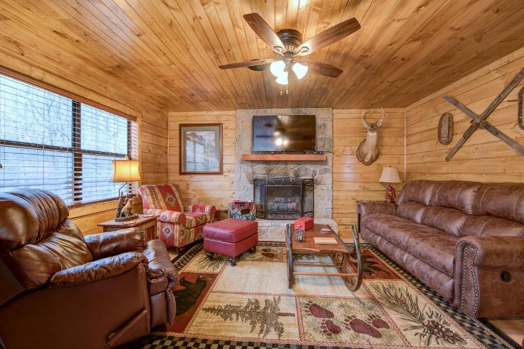 a living room with leather furniture and a fireplace at Rocky Top Lodge, 6 Bedrooms, Pool Access, Hot Tub, Mountain View, Sleeps 14 in Gatlinburg