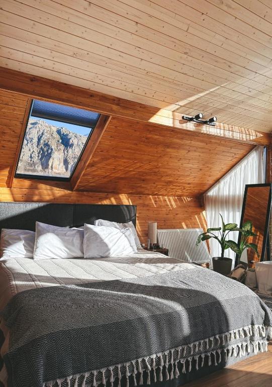a bedroom with a large bed with a window at Cottage Toladi in Kazbegi
