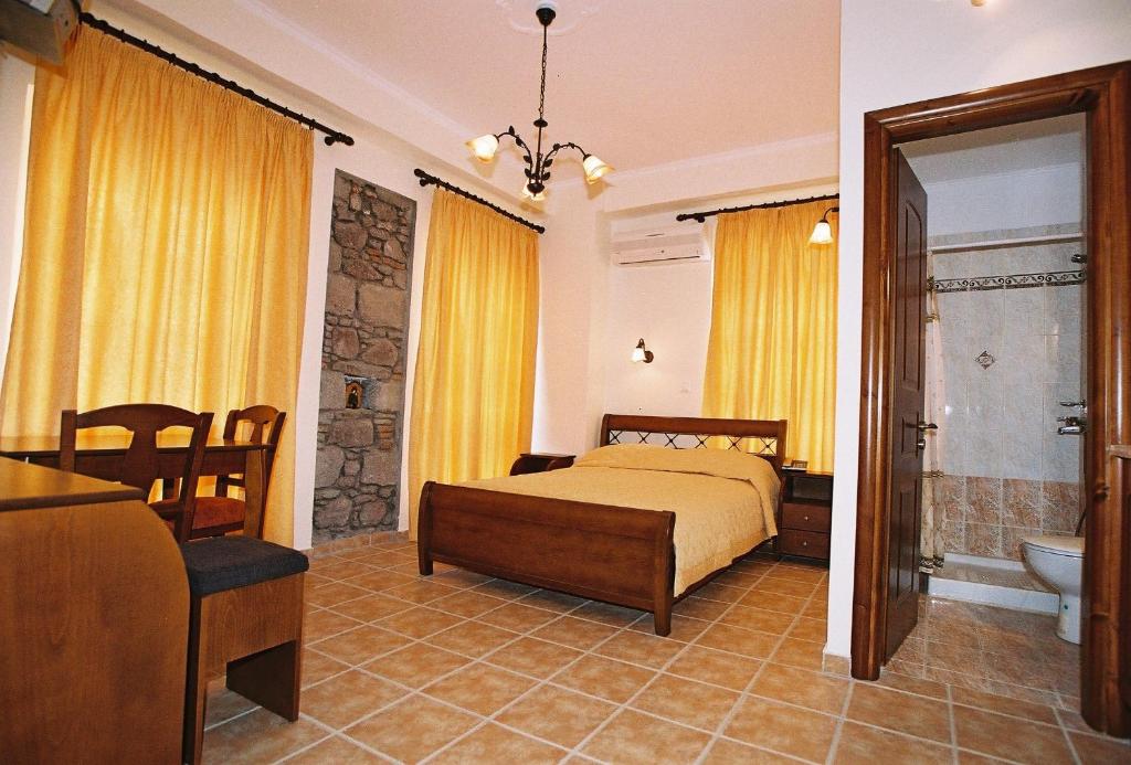 a bedroom with a bed and a bathroom at Artemis Traditional Hotel in Myrina