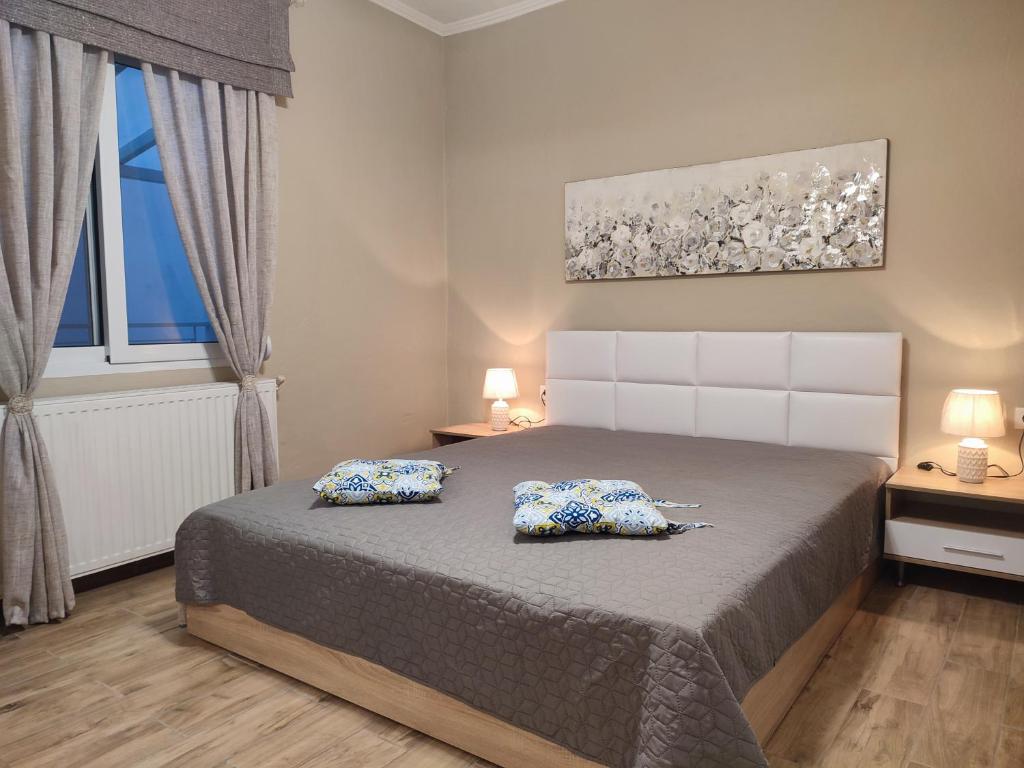 ein Schlafzimmer mit einem Bett mit zwei Kissen darauf in der Unterkunft ALICE'S ARt HOUSE in Kavala