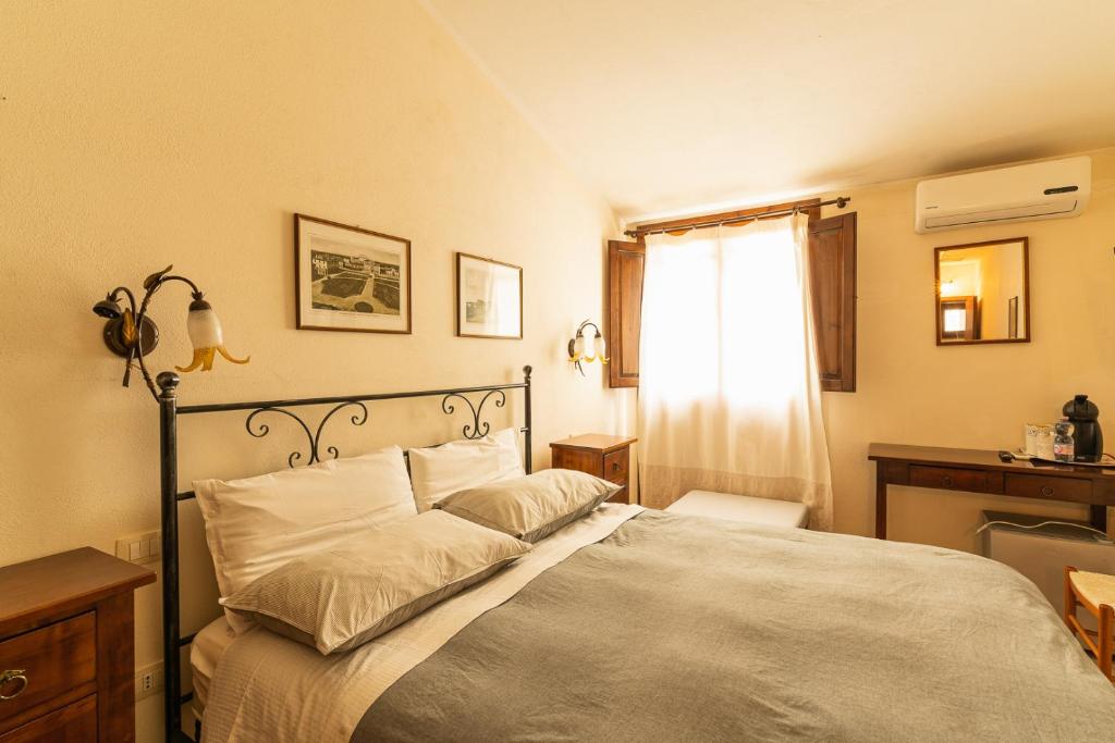 a bedroom with a bed and a desk and a window at Agriturismo Il Giglio in Oristano