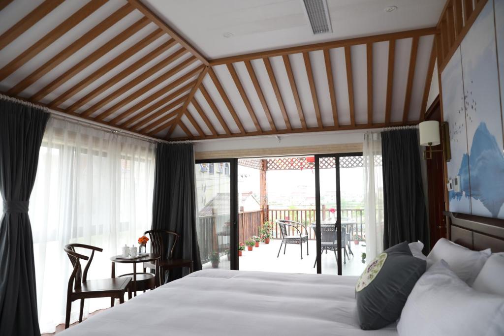 sypialnia z łóżkiem i balkonem w obiekcie Tian Yuan Jia She Haichang Ocean Park Dripping Lake w Szanghaju