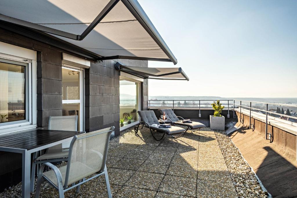 a patio with chairs and a table on a balcony at Chilli Home in Tettnang