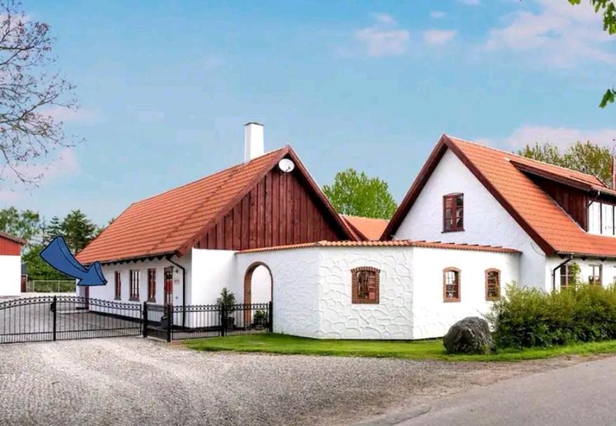 a large white house with a red roof at Birkevang holiday apartment in idyllic countryside in Faxe