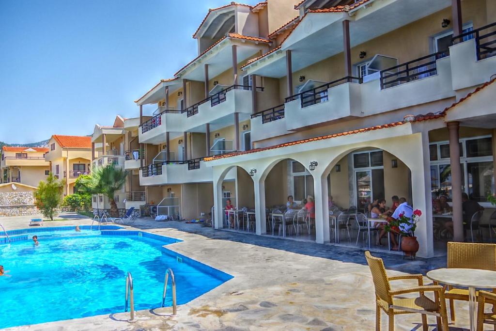 a hotel with a swimming pool in front of a building at Rachoni Resort in Skala Rachoniou