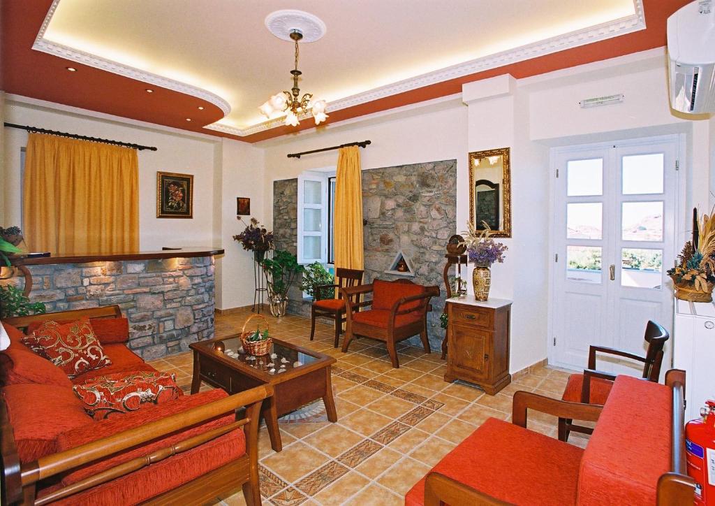 a living room with a couch and a stone wall at Artemis Traditional Hotel in Myrina