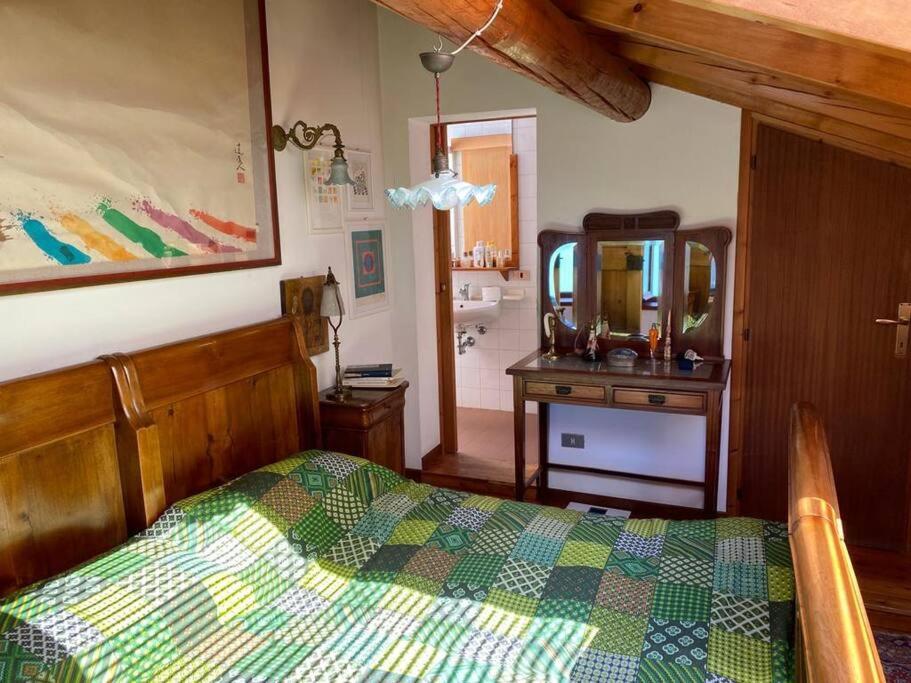 ein Schlafzimmer mit einem Bett und einem Waschtisch mit einem Spiegel in der Unterkunft La casetta del Professore in Olgiasca