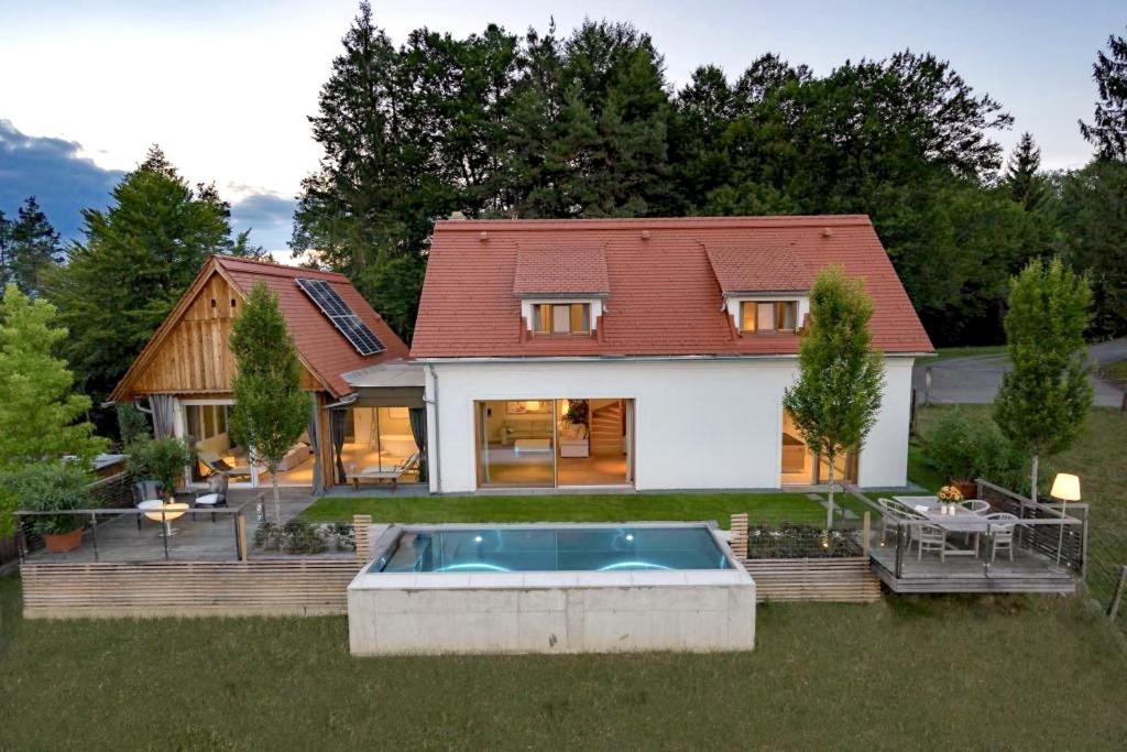 a house with a swimming pool in the yard at Hof Niglberg Südsteiermark in Sankt Johann im Saggautal