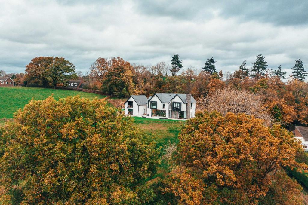 una casa en medio de un campo con árboles en The Loft Studio apartment - above detached new build garage en Llanymynech