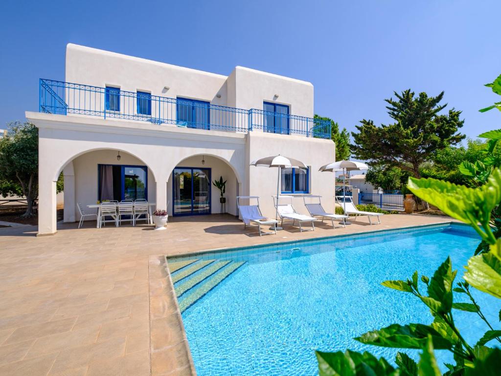 a villa with a swimming pool and a house at Sanders Azzurro in Peyia