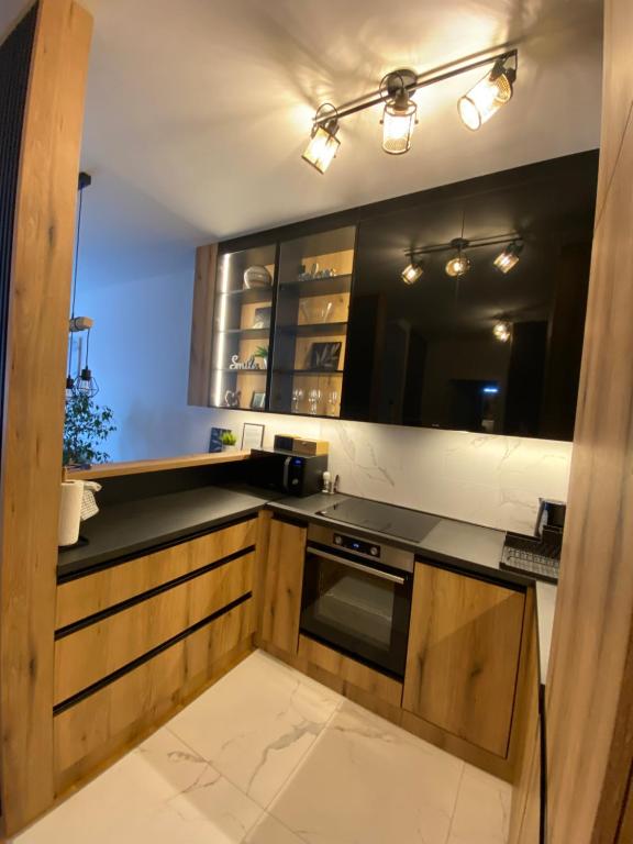 a kitchen with wooden cabinets and a stove at Apartment Unamare in Belgrade