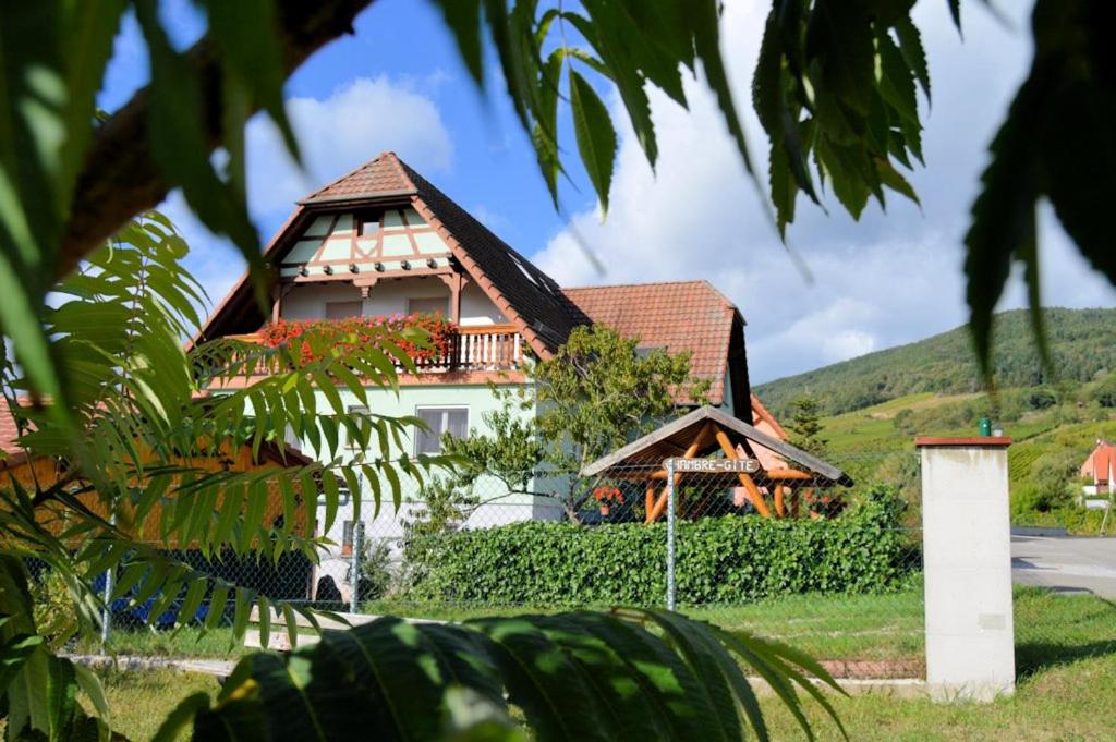 uma casa com uma varanda ao lado em Au Jardin d'Edel Gîtes Centre Alsace em Dieffenthal