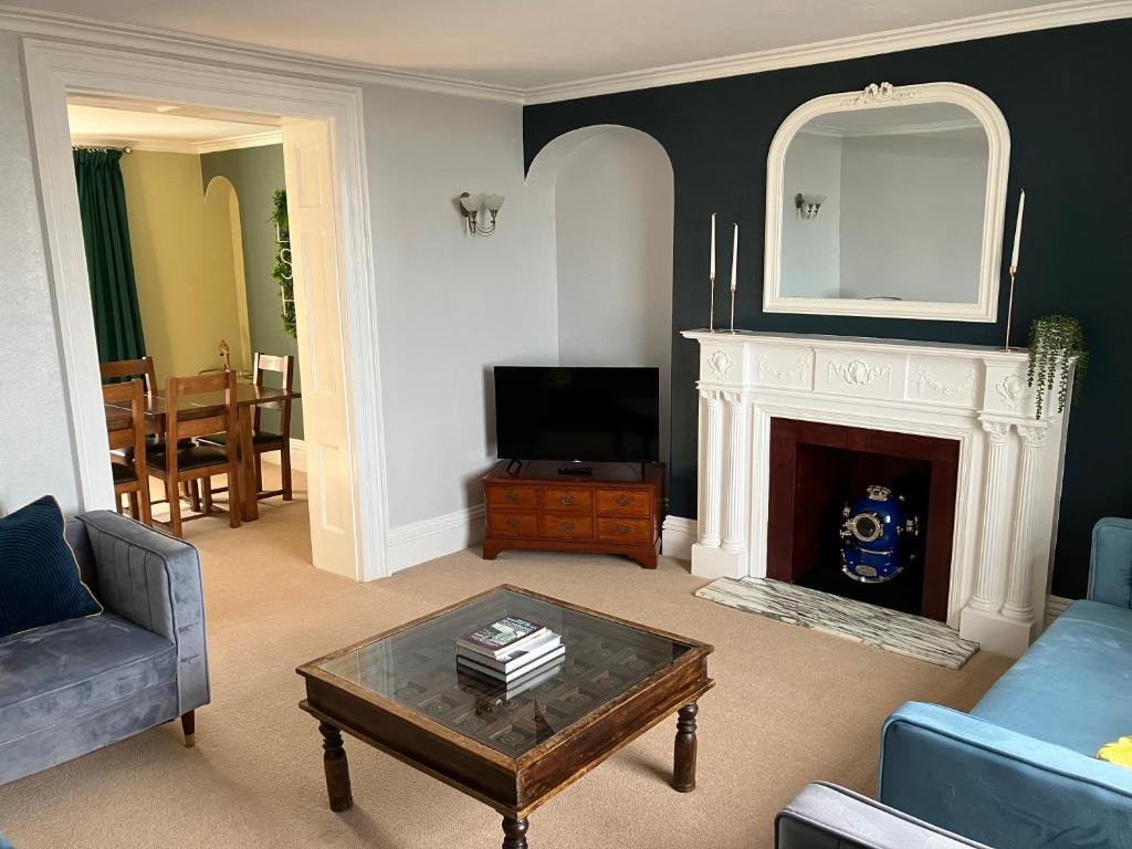 a living room with a fireplace and a tv at Lovely family seafront property in Burnham-on-Sea in Burnham on Sea