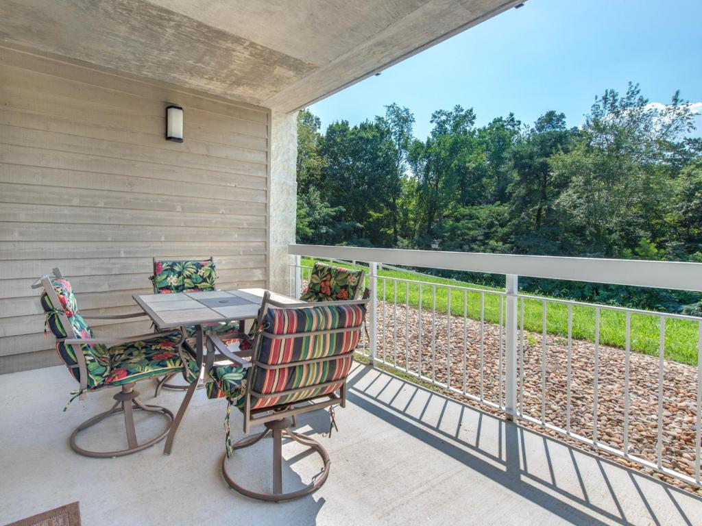 a patio with two chairs and a table on a balcony at Heart Of Pigeon Forge Whispering Pines 413HC in Pigeon Forge