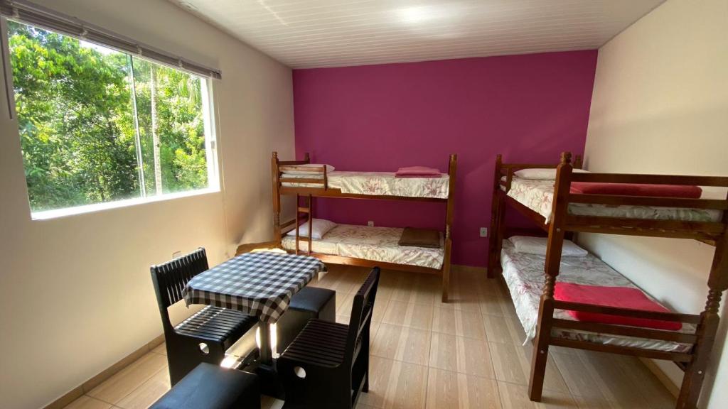a room with three bunk beds and a window at Cantinho do sossego in Blumenau