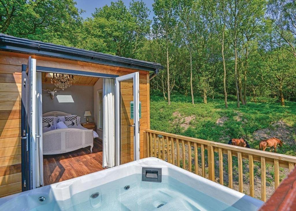 a jacuzzi tub on the deck of a cabin at Charlesworth Lodges in Glossop