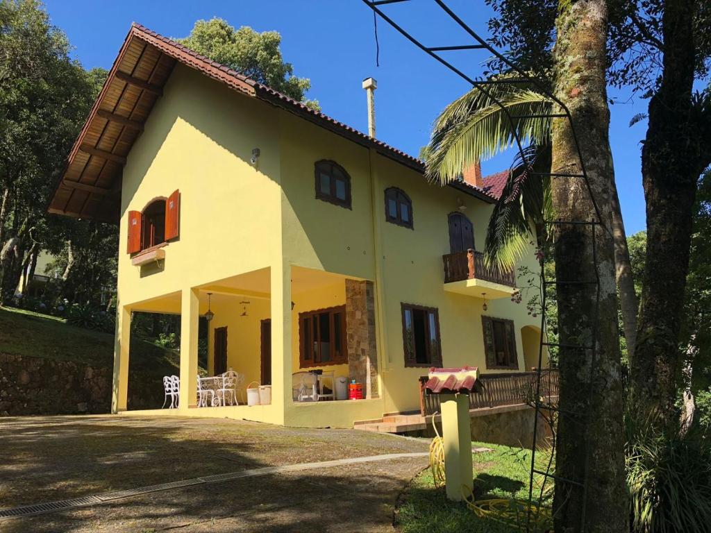蒙特沃德的住宿－Pousada 1800 Altitude Monte Verde，棕榈树的大型黄色房屋