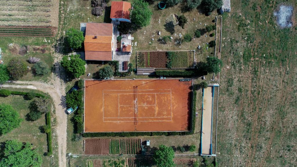 una vista aérea de una pista de tenis en un campo en Country house Oasis with private tennis court, en Sveti Filip i Jakov