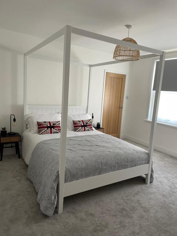 um quarto com uma cama de dossel branca em The Hideaway em Modbury