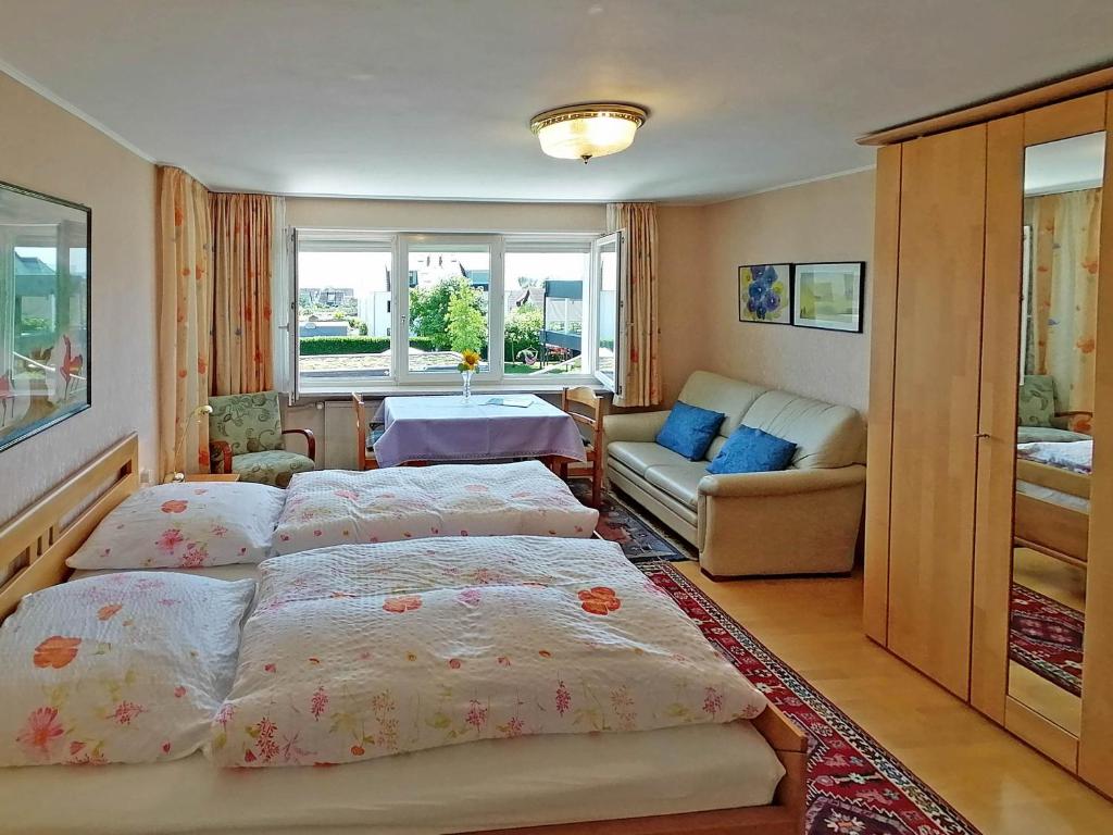 1 dormitorio con 3 camas y sala de estar en Haus Kees - Apartment, en Kressbronn am Bodensee