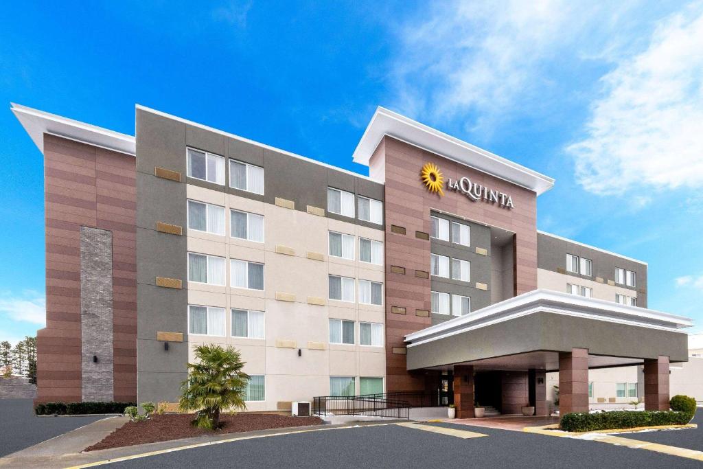 a hotel building with a sun sign on it at La Quinta Inn by Wyndham Lynnwood in Lynnwood