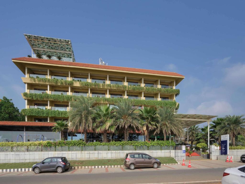 a building with cars parked in front of it at The Bheemli Resort Visakhapatnam by AccorHotels in Visakhapatnam