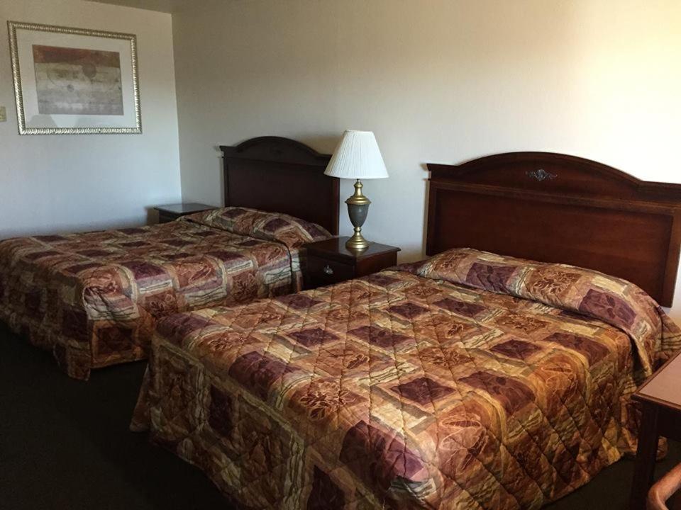 una habitación de hotel con 2 camas y una lámpara en Summer Wind Budget Motel, en Newport