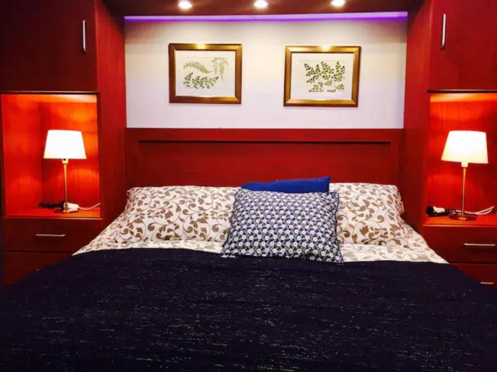 a bedroom with a bed with two lamps and pictures on the wall at The Royal Luxury Lion Patio in Amman