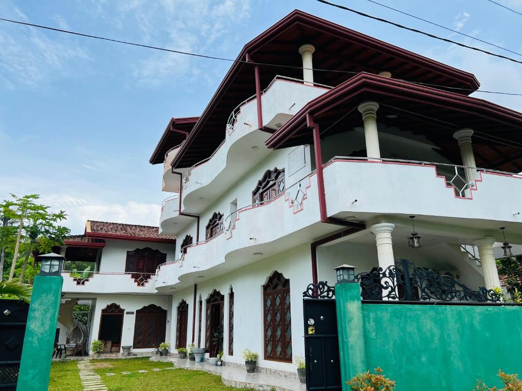 Biały dom z czerwonym dachem w obiekcie White Elephant Villa & Restaurant w mieście Beruwala