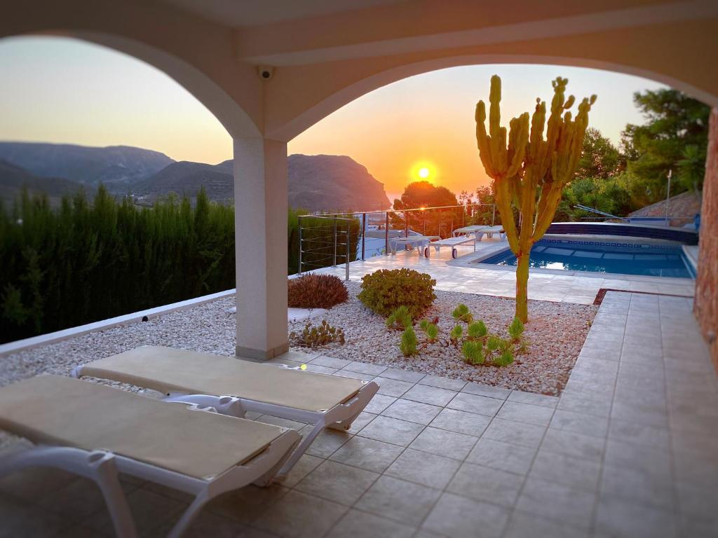 a patio with a cactus and a pool with the sunset at Oro y luz las negras in Las Negras