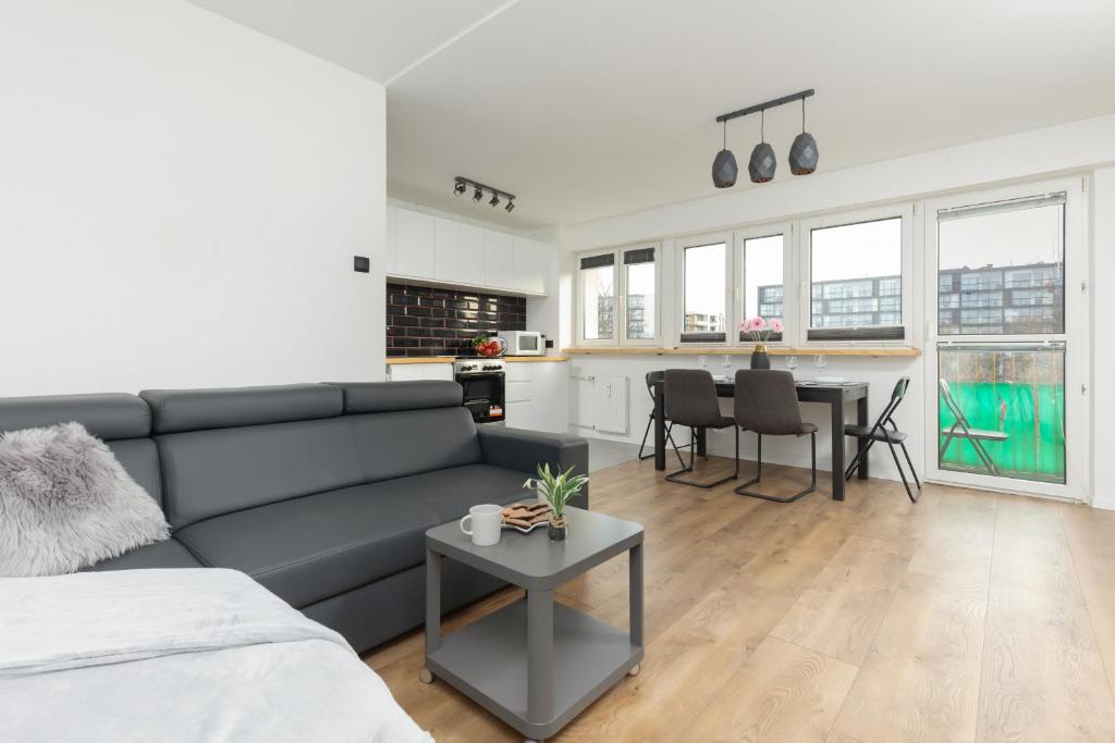 a living room with a couch and a table at Ochota Spacious Apartment with Parking by Renters in Warsaw