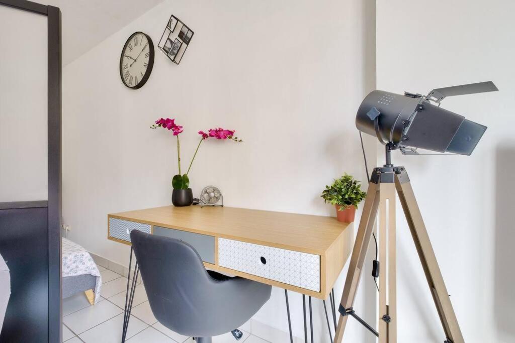 a desk with a camera and a desk with a clock at Studio cosy idéal pour 2 personnes situé à Lyon in Lyon