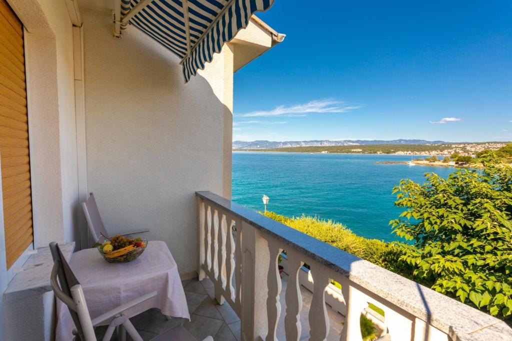 a balcony with a table and a view of the water at Apartments Dinka Vantačići in Malinska