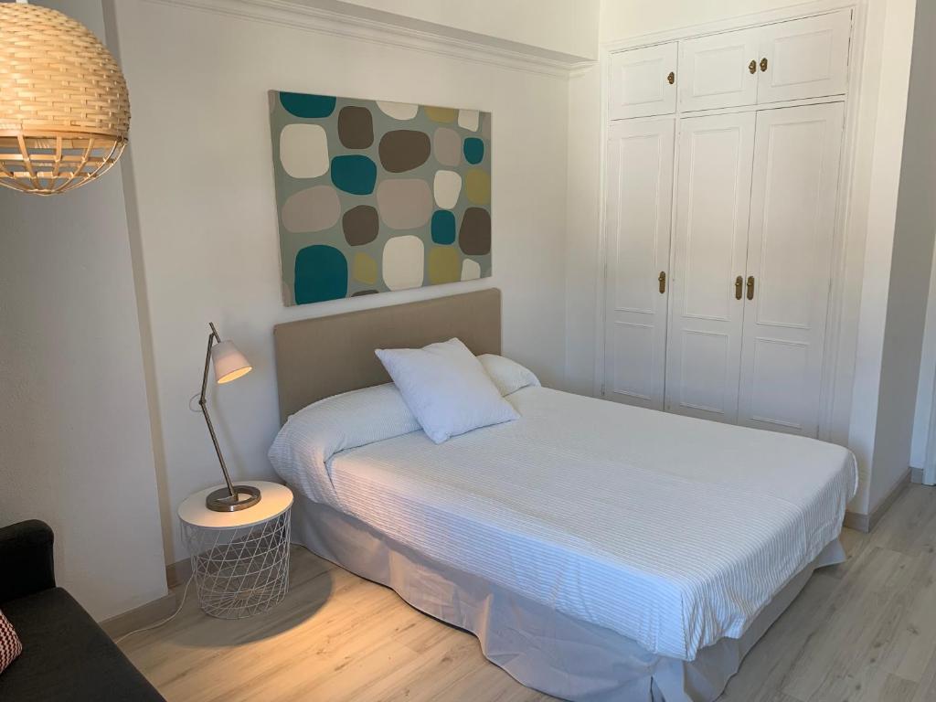 Dormitorio pequeño con cama y lámpara en Apartamentos Bruja, en Santa Cruz de Tenerife