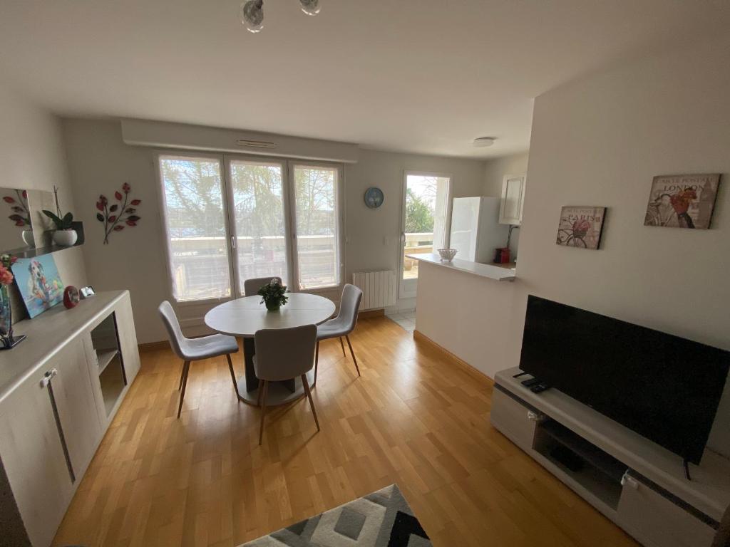 a living room with a table and a tv at Appartement moderne cœur des châteaux de la Loire - Parking in Blois