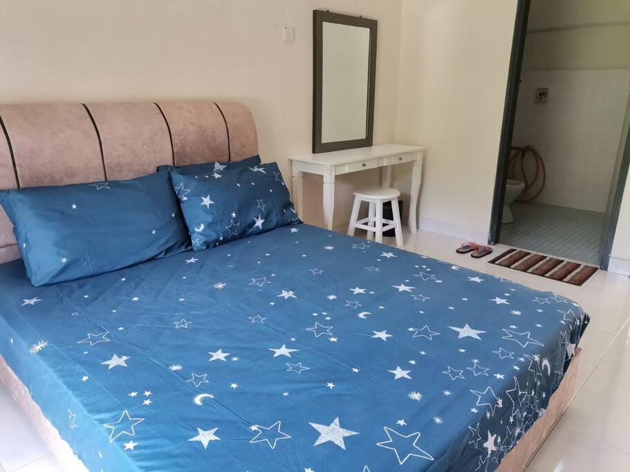 ein Bett mit blauer Decke mit Sternen darauf in der Unterkunft Eng Ban Hin guesthouse in Malakka