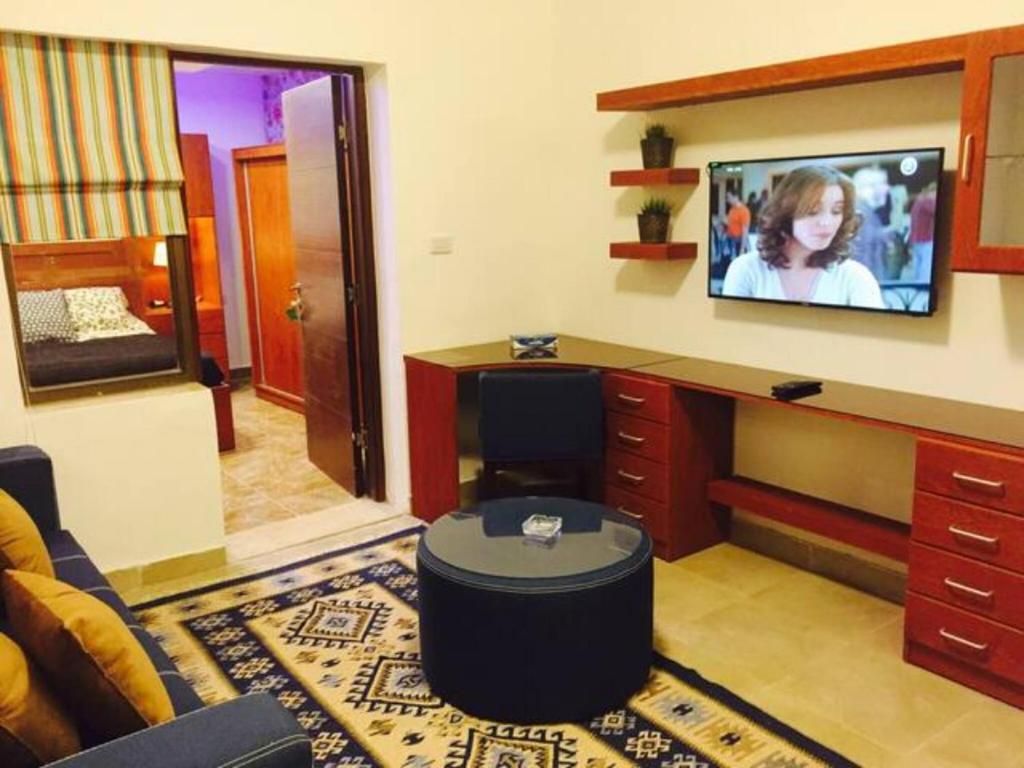 sala de estar con TV en la pared en The Royal Luxury Tiger Patio en Amán