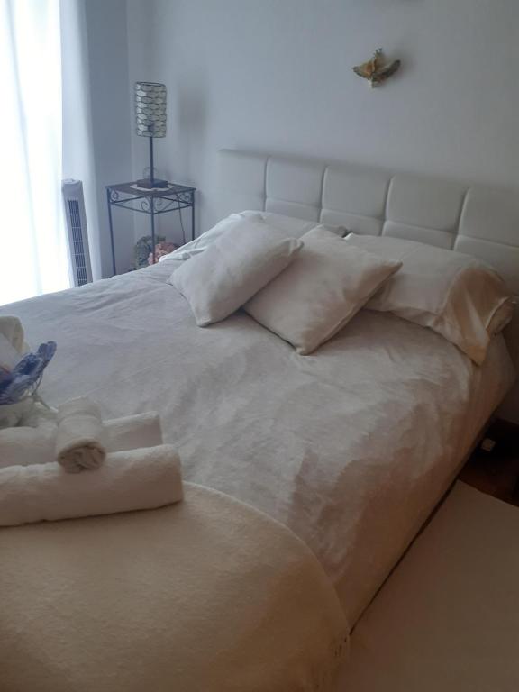 a large bed with white sheets and pillows at Efd Varzea Park in Funchal