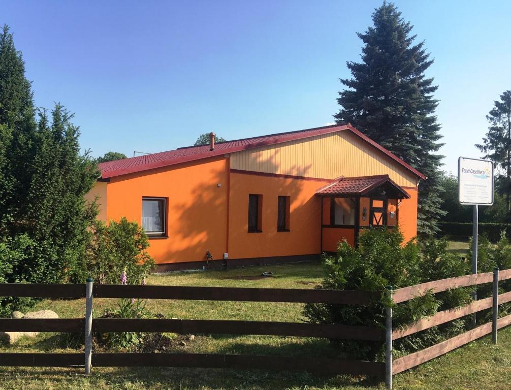 an orange house with a fence in front of it at Abendsonne in Mirow