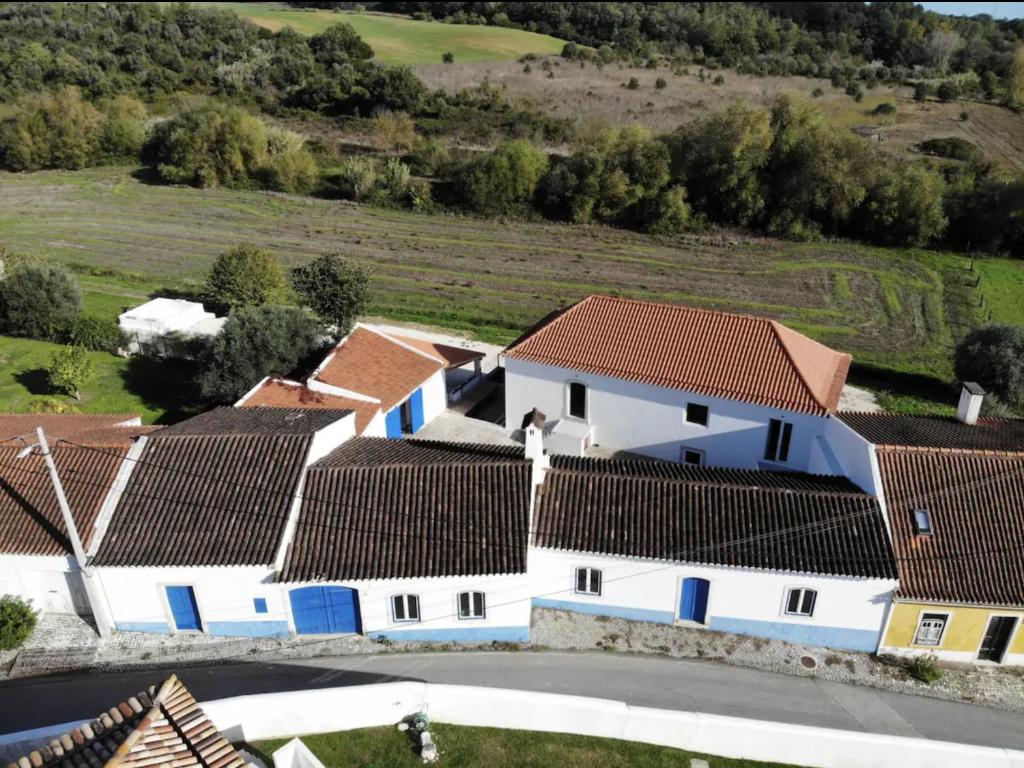 Azoia de Baixo的住宿－Azoia 10 - Casas de Campo & Hostel，享有一排白色房屋的空中景色,设有棕色屋顶