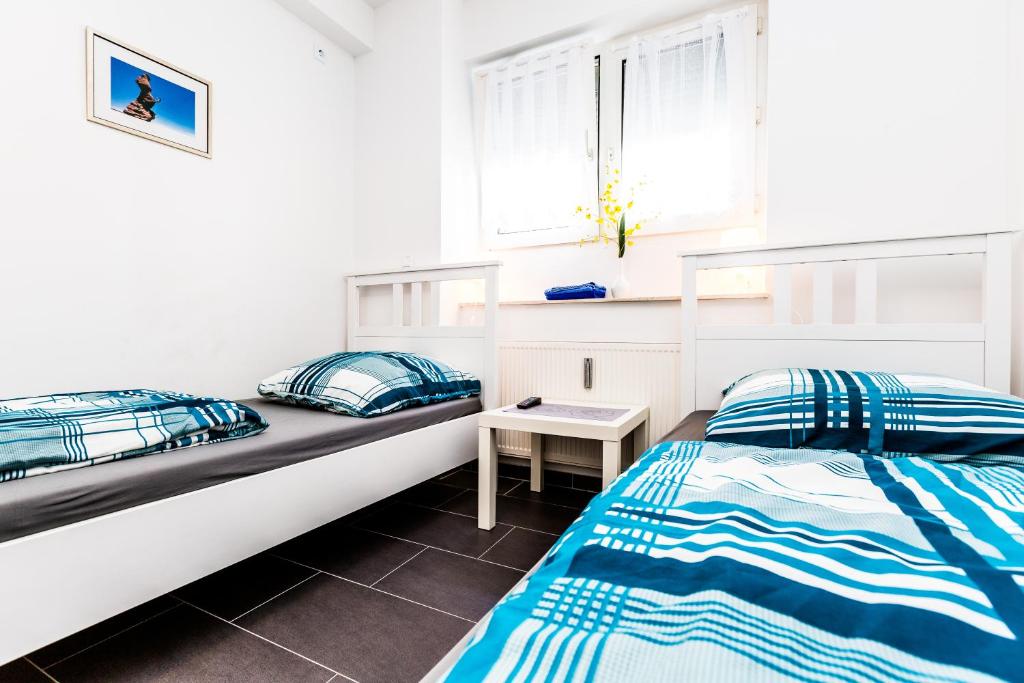 1 dormitorio con 2 camas y ventana en Messewohnung Buchforst en Colonia