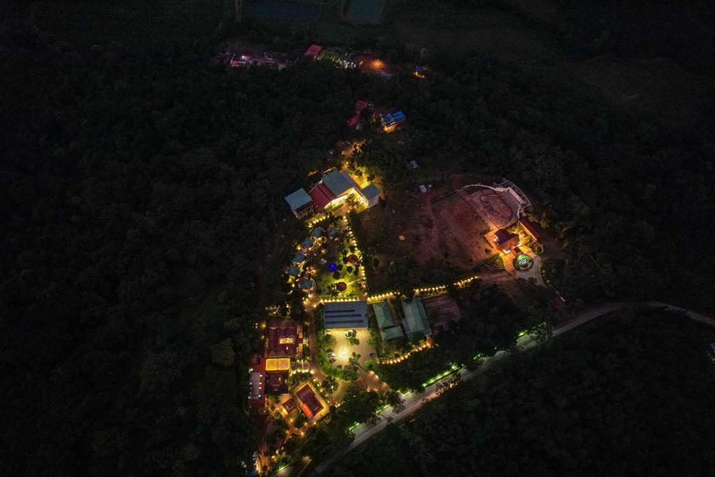 een uitzicht op een gebouw 's nachts met verlichting bij Honeydewwz Exoticaa Hotel & Resort in Chikmagalūr