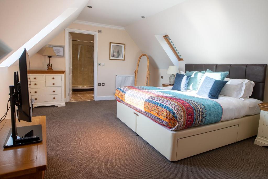 a bedroom with a bed and a flat screen tv at Terlingham Lane Cottage in Folkestone