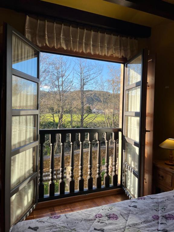 a bedroom with a large window with a view at Apartamentos Turisticos Paseo de la Alameda in Villaviciosa