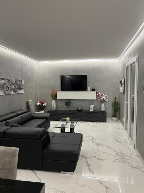 a living room with a black couch and a tv at Corso montecarlo in Ventimiglia