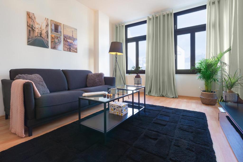 a living room with a blue couch and a glass table at Ruhige Wohnung in zentraler Lage - Quiet flat in a central location in Magdeburg