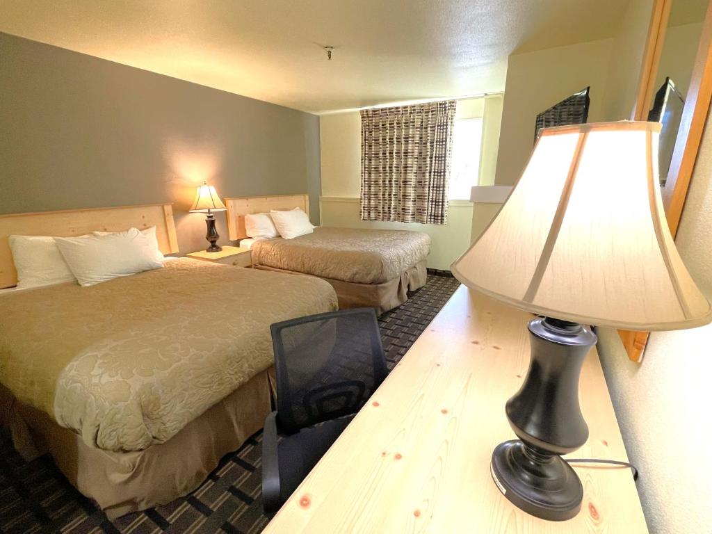 a hotel room with two beds and a lamp at FairBridge Inn - Coeur d'Alene in Coeur d'Alene